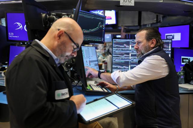 Traders work on the floor of the New York Stock Exchange (NYSE) in New York on November 21, 2025. Wall Street stocks rebounded early Friday after a Federal Reserve official's remarks reignited hopes of a third consecutive US interest rate cut in December. (Photo by ANGELA WEISS / AFP)