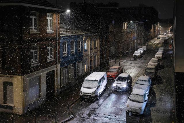 A car drives through a street during a snow fall in Lille, northern France on November 21, 2025. (Photo by Sameer Al-DOUMY / AFP)