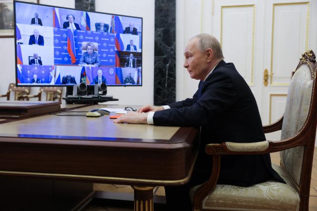 In this pool photograph distributed by the Russian state agency Sputnik, Russia's President Vladimir Putin chairs a Security Council meeting via a videoconference at the Kremlin in Moscow on November 21, 2025. (Photo by Gavriil Grigorov / POOL / AFP)