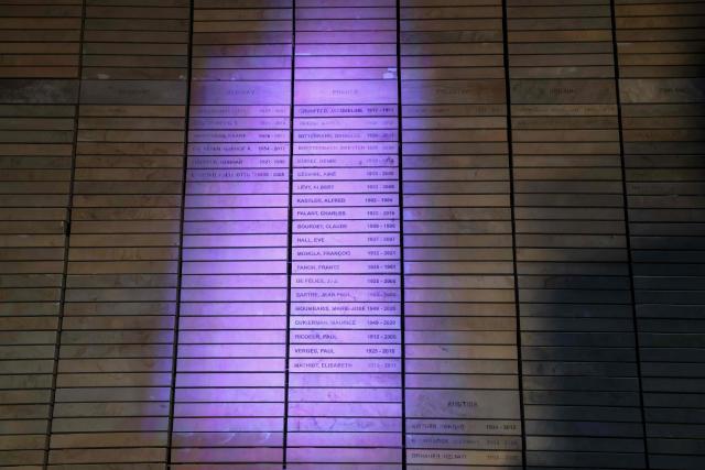 A wall with names of French individuals who fought against apartheid is seen lit up during a commemoration ceremony attended by South Africa's Deputy President Paul Mashatile and France’s President Emmanuel Macron at Freedom Park in Pretoria on November 21, 2025 ahead of the G20 leaders' Summit. (Photo by Ludovic MARIN / AFP)