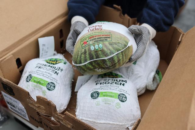 A person holds a frozen turkey during a Thanksgiving food distribution event outside of Brooklyn Borough Hall on November 21, 2025 in New York City. Fresh produce, non-perishables and other food items were handed out to 125 Brooklyn houses of worship, community kitchens and other community-based organizations addressing food insecurity and homelessness. (Photo by ANGELA WEISS / AFP)