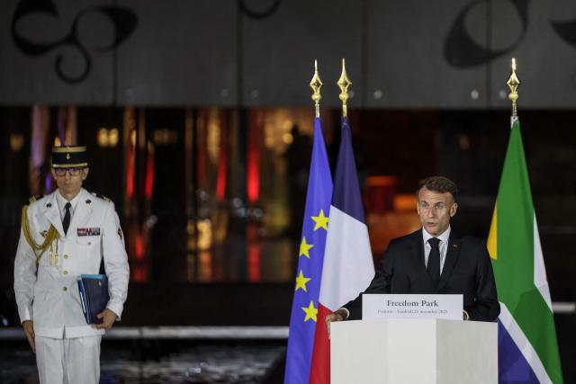 France’s President Emmanuel Macron (R) speaks as he attends a commemoration ceremony, for French individuals who fought against apartheid, at Freedom Park in Pretoria on November 21, 2025 ahead of the G20 leaders' Summit. (Photo by Ludovic MARIN / AFP)
