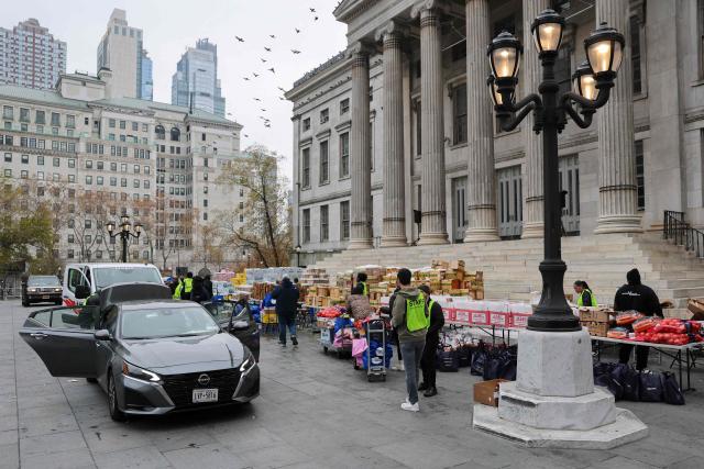 Volunteers distribute food during a Thanksgiving food distribution event outside of Brooklyn Borough Hall on November 21, 2025 in New York City. Fresh produce, non-perishables and other food items were handed out to 125 Brooklyn houses of worship, community kitchens and other community-based organizations addressing food insecurity and homelessness. (Photo by ANGELA WEISS / AFP)