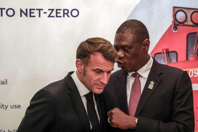 France’s President Emmanuel Macron (L) speaks with South Africa's Deputy President Paul Mashatile (R) at the launch of the Franco-South African Business Council, at the French Ambassador to South Africa's residence in Pretoria on November 21, 2025 ahead of the G20 leaders' Summit. (Photo by Ludovic MARIN / AFP)