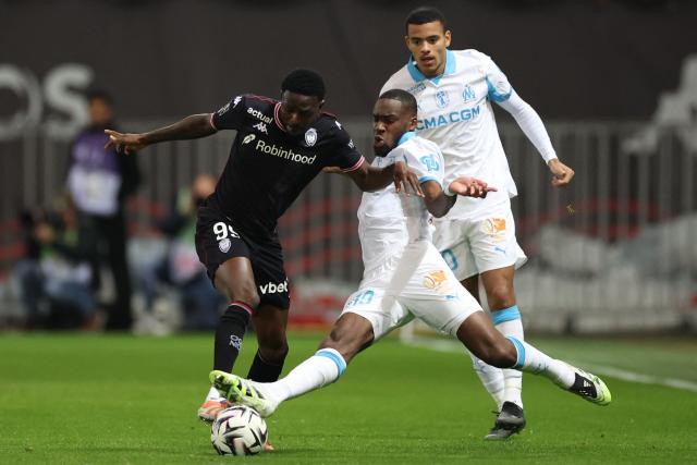 Nice's Ghanaian midfielder #99 Salis Abdul Samed (L) fights for the ball with Marseille's Central African Republic's midfielder #19 Geoffrey Kondogbia (C) during the French L1 football match between OGC Nice and Olympique de Marseille (OM) at the Allianz Riviera stadium in Nice, south-eastern France, on November 21, 2025. (Photo by Valery HACHE / AFP)