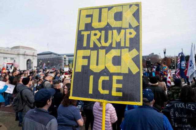 A demonstrator holds a sign during the Veterans' Rally as part of the "Remove the Regime" protests against US President Donald Trump at Union Station near the US Capitol in Washington, DC, on November 21, 2025. The "Remove the Regime" protests are convened by The Removal Coalition, an umbrella group composed of several activist organizations. (Photo by SAUL LOEB / AFP)