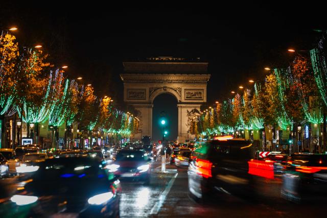 This long exposure photograph shows the Champs Elysees Avenue with Christmas illuminations and the Arc de Triomphe in the background, in Paris, on November 21, 2025. (Photo by Dimitar DILKOFF / AFP)