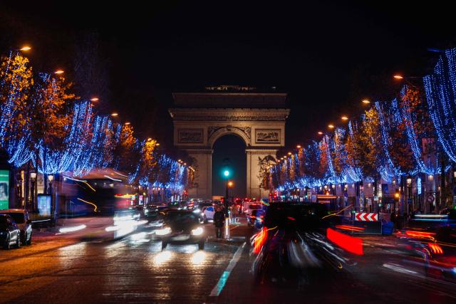 This long exposure photograph shows the Champs Elysees Avenue with Christmas illuminations and the Arc de Triomphe in the background, in Paris, on November 21, 2025. (Photo by Dimitar DILKOFF / AFP)