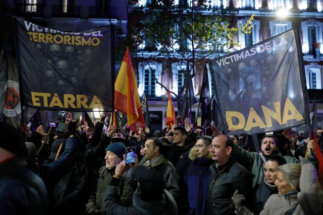 Demonstrators hold banners and perform the fascist salute during a demonstration called by Falange Espanola de las JONS fascist party in Madrid, on November 21, 2025, marking the 50th anniversary of Spanish dictator Francisco Franco's death. Prime Minister Pedro Sanchez yesterday called on Spaniards to defend the "miracle" of their democracy as the divided country marked the 50th anniversary of ex-dictator Francisco Franco's death. The general's demise on November 20, 1975 ended 36 years of authoritarian right-wing rule that followed a devastating 1936-1939 civil war which brought him to power. (Photo by Oscar DEL POZO / AFP)