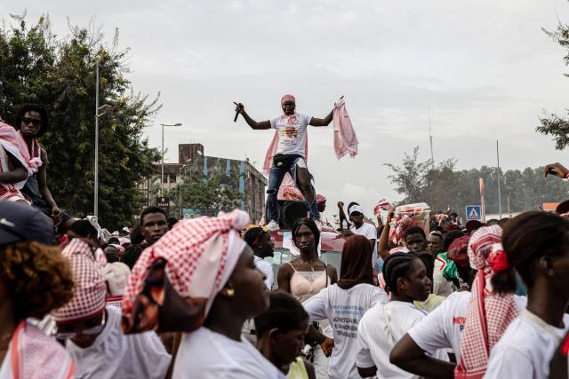 A supporter of Guinea-Bissau's President and presidential candidate Umaro Sissoco Embalo dances on top of a vehicle during his final campaign rally ahead of general elections, in Bissau, on November 21, 2025. Guinea-Bissau votes in general elections on November 23, 2025. (Photo by PATRICK MEINHARDT / AFP)