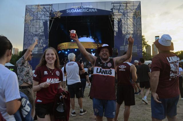 Fans of Lanus cheer while gathering at the Fan Zone in Asuncion on November 21, 2025, on the eve of the Copa Sudamericana final football match between Argentina's Lanus and Brazil's Atletico Mineiro. (Photo by DANIEL DUARTE / AFP)