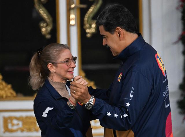 Venezuela's President Nicolas Maduro dances with his wife Cilia Flores during the student day celebrations at Miraflores palace in Caracas, November 21, 2025. (Photo by Juan BARRETO / AFP)