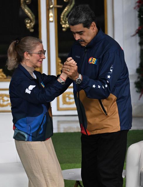 Venezuela's President Nicolas Maduro dances with his wife Cilia Flores during the student day celebrations at Miraflores palace in Caracas, November 21, 2025. (Photo by Juan BARRETO / AFP)