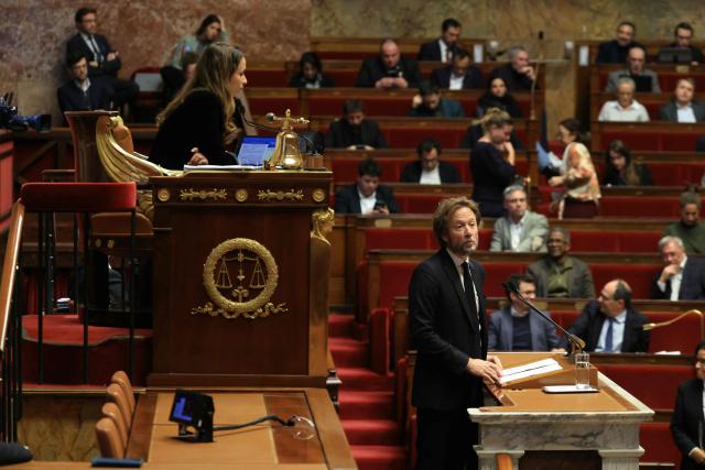 La France Insoumise-Nouveau Front Populaire's MP and National Assembly vice-president Clemence Guette (L) listens as the President of Socialistes et Apparentes parliamentary group Boris Vallaud speaks during a debate session on the draft budget law for 2026 at the Assemblee Nationale, France's Parliament lower house, in Paris early on November 22, 2025. (Photo by Alain JOCARD / AFP)