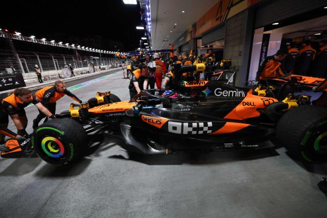 McLaren technicians push McLaren's Australian driver Oscar Piastri and his car into the garage during the third practice session for the Las Vegas Formula One Grand Prix at the Las Vegas Strip Circuit in Las Vegas, Nevada, on November 21, 2025. (Photo by Patrick T. Fallon / AFP)