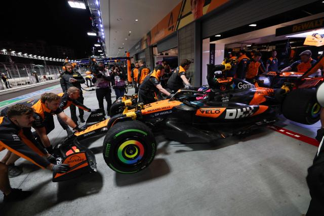 McLaren technicians push McLaren's Australian driver Oscar Piastri and his car into the garage during the third practice session for the Las Vegas Formula One Grand Prix at the Las Vegas Strip Circuit in Las Vegas, Nevada, on November 21, 2025. (Photo by Patrick T. Fallon / AFP)