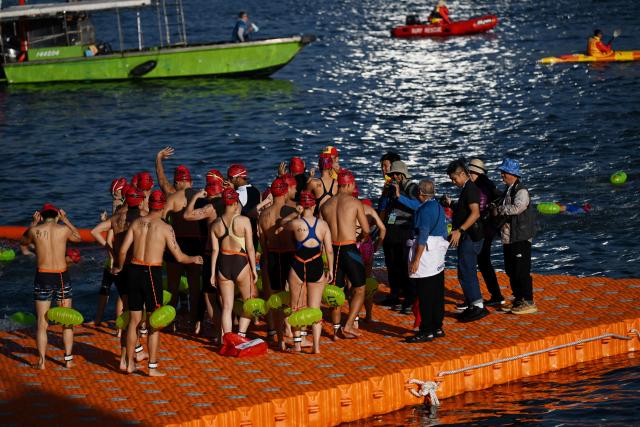 Participants prepare to take part in the Harbour Race, where swimmers cross Hong Kong's Victoria Harbour, in the city on November 22, 2025. (Photo by Peter PARKS / AFP)