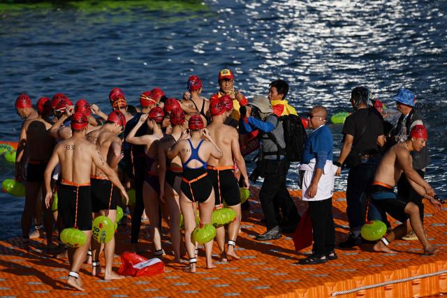Participants prepare to take part in the Harbour Race, where swimmers cross Hong Kong's Victoria Harbour, in the city on November 22, 2025. (Photo by Peter PARKS / AFP)