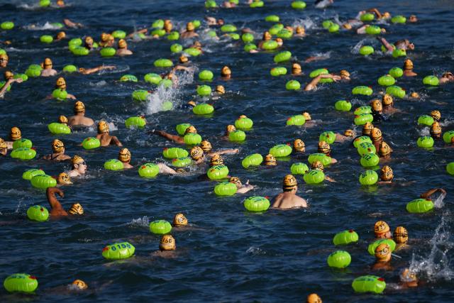 Participants take part in the Harbour Race, where swimmers cross Hong Kong's Victoria Harbour, in the city on November 22, 2025. (Photo by Peter PARKS / AFP)