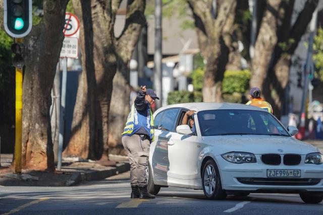 A Johannesburg Metro Police Department (JMPD) officer directs traffic on a road leading to the Nasrec Expo Centre, in Rosebank, Johannesburg on November 22, 2025, ahead of the opening of the G20 Leaders’ Summit. (Photo by Zinyange Auntony / AFP)