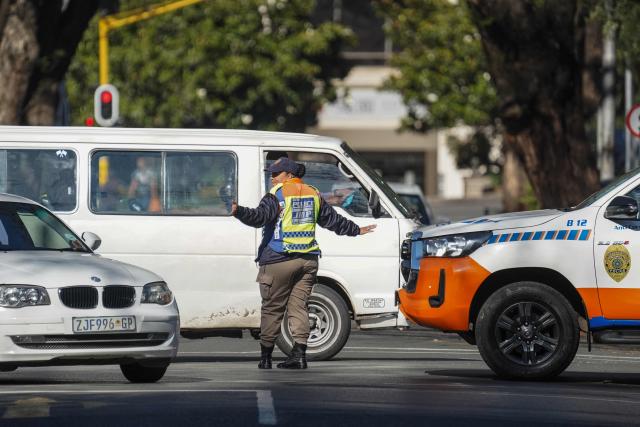 Johannesburg Metro Police Department (JMPD) officer directs traffic on a road leading to the Nasrec Expo Centre, in Rosebank, Johannesburg on November 22, 2025, ahead of the opening of the G20 Leaders’ Summit. (Photo by Zinyange Auntony / AFP)