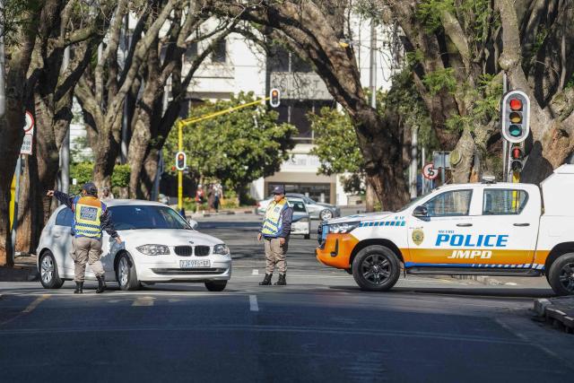 A Johannesburg Metro Police Department (JMPD) officer directs traffic on a road leading to the Nasrec Expo Centre, in Rosebank, Johannesburg on November 22, 2025, ahead of the opening of the G20 Leaders’ Summit. (Photo by Zinyange Auntony / AFP)