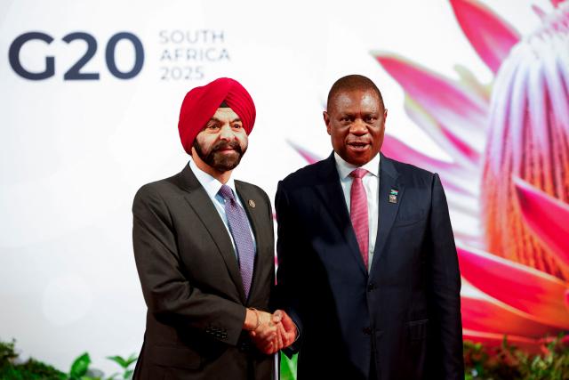 South Africa's Deputy President Paul Mashatile welcomes World Bank President Ajay Banga as he arrives for the opening of the G20 Leaders' Summit at the Nasrec Expo Centre in Johannesburg on November 22, 2025. (Photo by Thomas Mukoya / POOL / AFP)
