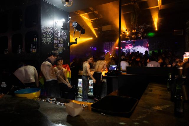 Bartenders gather behind the counter during a G20-themed drag show at the Babylon nightclub in Johannesburg on November 22, 2025, ahead of the opening of the G20 Leader's Summit. (Photo by CAMILLA RICHETTI / AFP)