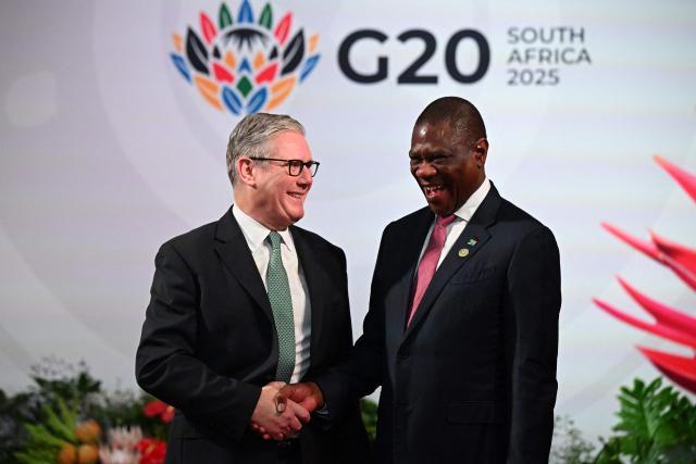 South Africa's Deputy President Paul Mashatile (R) welcomes Britain's Prime Minister Keir Starmer (L)  upon his arrival for the opening of the G20 Leaders' Summit at the Nasrec Expo Centre in Johannesburg on November 22, 2025. (Photo by Leon Neal / POOL / AFP)