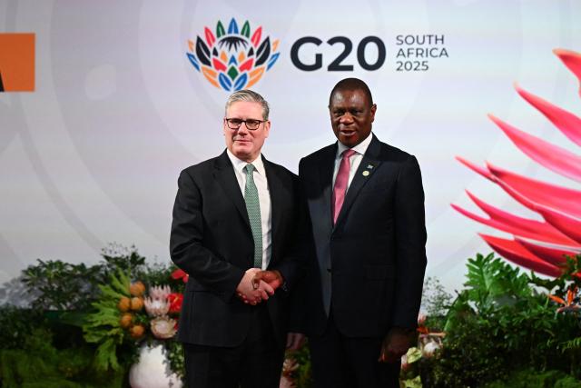 South Africa's Deputy President Paul Mashatile (R) welcomes Britain's Prime Minister Keir Starmer (L)  upon his arrival for the opening of the G20 Leaders' Summit at the Nasrec Expo Centre in Johannesburg on November 22, 2025. (Photo by Leon Neal / POOL / AFP)