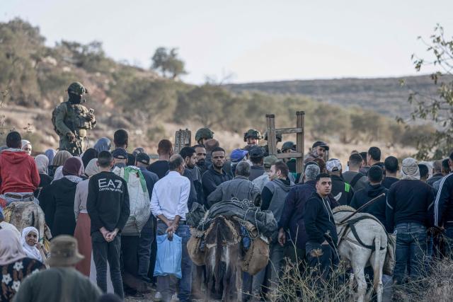 Israeli soldiers stop Palestinian farmers from Salem village at a checkpoint before entering through a close gate onto their land to pick olives, east of Nablus in the occupied West Bank, on November 22, 2025. (Photo by Jaafar ASHTIYEH / AFP)