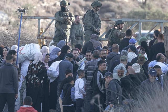 Israeli soldiers stop Palestinian farmers from Salem village at a checkpoint before entering through a close gate onto their land to pick olives, east of Nablus in the occupied West Bank, on November 22, 2025. (Photo by Jaafar ASHTIYEH / AFP)