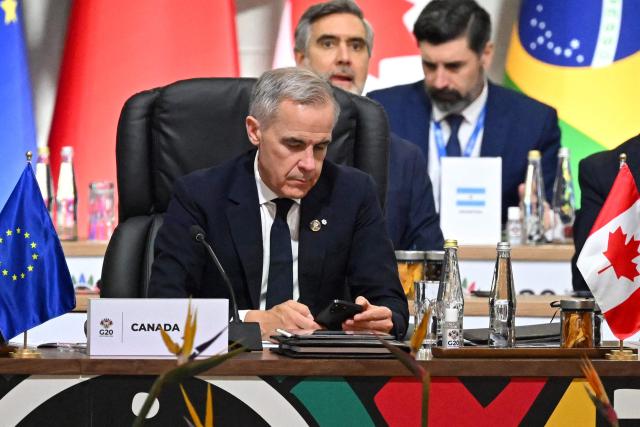 Canadian Prime Minister Mark Carney waits for the start of a G20 Leaders' Summit plenary session at the Nasrec Expo Centre in Johannesburg on November 22, 2025. (Photo by Leon Neal / POOL / AFP)