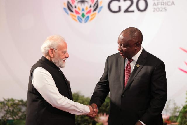 South African President Cyril Ramaphosa (R) welcomes Indian Prime Minister Narendra Modi as he arrives for the opening of the G20 Leaders' Summit at the Nasrec Expo Centre in Johannesburg on November 22, 2025. (Photo by Halden KROG / POOL / AFP)