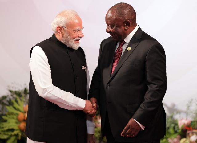 South African President Cyril Ramaphosa (R) welcomes Indian Prime Minister Narendra Modi as he arrives for the opening of the G20 Leaders' Summit at the Nasrec Expo Centre in Johannesburg on November 22, 2025. (Photo by Halden KROG / POOL / AFP)