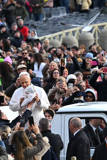 Pope Leo XIV (L) blesses a child from the papamobile as he arrives to the audience of Jubilee of Choirs and Choral Society at St Peter's Square in the Vatican on November 22, 2025. (Photo by Andreas SOLARO / AFP)