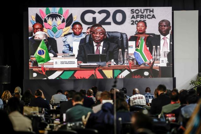 Members of the media follow remarks by South African President Cyril Ramaphosa on a screen in the media centre during the G20 Leaders’ Summit plenary session at the Nasrec Expo Centre in Johannesburg on November 22, 2025. (Photo by GIANLUIGI GUERCIA / AFP)