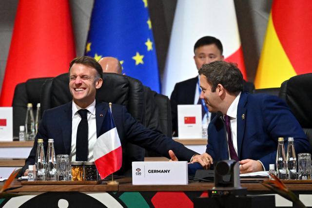 France's President Emmanuel Macron (L) share a laugh with German Finance Minister and Vice Chancellor Lars Klingbeil during a G20 Leaders' Summit plenary session at the Nasrec Expo Centre in Johannesburg on November 22, 2025. (Photo by Leon Neal / POOL / AFP)