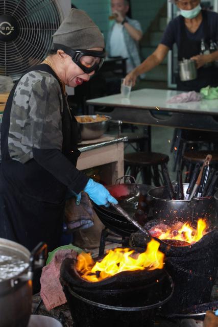 Michelin star chef Jay Fai, a longtime icon of Thai street food culture, cooks at her restaurant in Bangkok on November 22, 2025. (Photo by Sebastien BERGER / AFP)