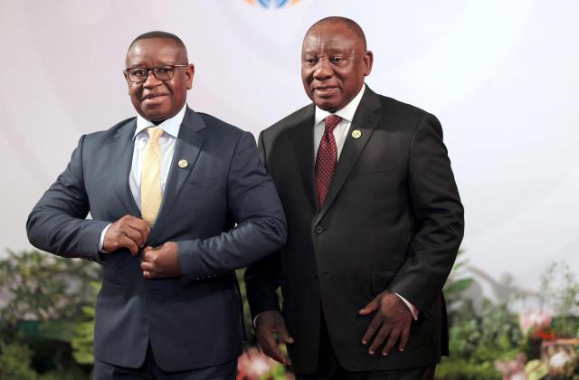 South African President Cyril Ramaphosa (R) welcomes Julius Maada Bio, President of Sierra Leone as he arrives for the opening of the G20 Leaders' Summit at the Nasrec Expo Centre in Johannesburg on November 22, 2025. (Photo by Halden KROG / POOL / AFP)