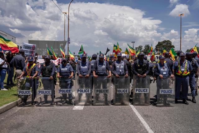 South African riot police officers line up as members of the All United Amhara Association protest against the persecution of the Amhara people in Ethiopia and Ethiopian Prime Minister Abiy Ahmed Ali's attendance at the G20 Leaders' Summit, near the Nasrec Expo Centre in Johannesburg on November 22, 2025 during of the opening of the G20 Leaders’ Summit. (Photo by Ihsaan Haffejee / AFP)