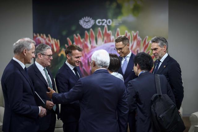 Britain's Prime Minister Keir Starmer (2nd L) and France’s President Emmanuel Macron (3rd L) speak to delegates ahead of the G7++ meeting on the sidelines of a G20 Leaders' Summit plenary session at the Nasrec Expo Centre in Johannesburg on November 22, 2025. (Photo by HENRY NICHOLLS / POOL / AFP)