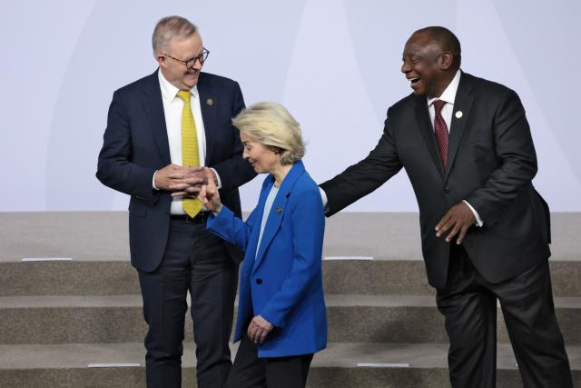 European Commission President Ursula von der Leyen reacts with Australia's Prime Minister Anthony Albanese and South Africa's President Cyril Ramaphosa duringa family photo event during a G20 Leaders' Summit plenary session at the Nasrec Expo Centre in Johannesburg on November 22, 2025. (Photo by Yves Herman / POOL / AFP)