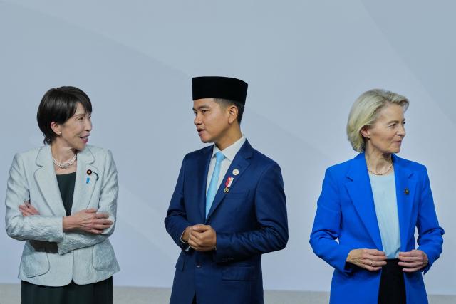 Japan's Prime Minister Sanae Takaichi (L) and Indonesia's Vice President Gibran Rakabuming Raka, flanked by EU Commission President Ursula Von der Leyen attend a family photo event during a G20 Leaders' Summit plenary session at the Nasrec Expo Centre in Johannesburg on November 22, 2025. (Photo by Misper Apawu / POOL / AFP)