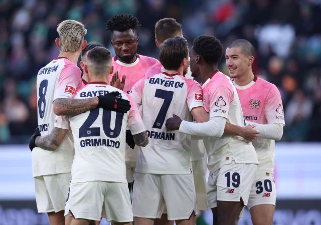 Bayer Leverkusen's German midfielder #07 Jonas Hofmann celebrates with teammates scoring the opening goal during the German first division Bundesliga football match between VfL Wolfsburg and Bayer Leverkusen in Wolfsburg on November 22, 2025. (Photo by Ronny HARTMANN / AFP) / DFL REGULATIONS PROHIBIT ANY USE OF PHOTOGRAPHS AS IMAGE SEQUENCES AND/OR QUASI-VIDEO
