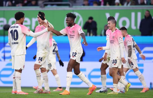 Bayer Leverkusen's Burkinabe defender #12 Edmond Tapsoba celebrates with teammates scoring his team's second goal during the German first division Bundesliga football match between VfL Wolfsburg and Bayer Leverkusen in Wolfsburg on November 22, 2025. (Photo by Ronny HARTMANN / AFP) / DFL REGULATIONS PROHIBIT ANY USE OF PHOTOGRAPHS AS IMAGE SEQUENCES AND/OR QUASI-VIDEO
