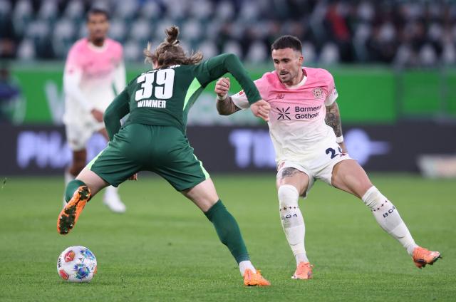 Wolfsburg's Austrian midfielder #39 Patrick Wimmer (L) and Bayer Leverkusen's Spanish midfielder #24 Aleix Garcia vie for the ball during the German first division Bundesliga football match between VfL Wolfsburg and Bayer Leverkusen in Wolfsburg on November 22, 2025. (Photo by Ronny HARTMANN / AFP) / DFL REGULATIONS PROHIBIT ANY USE OF PHOTOGRAPHS AS IMAGE SEQUENCES AND/OR QUASI-VIDEO