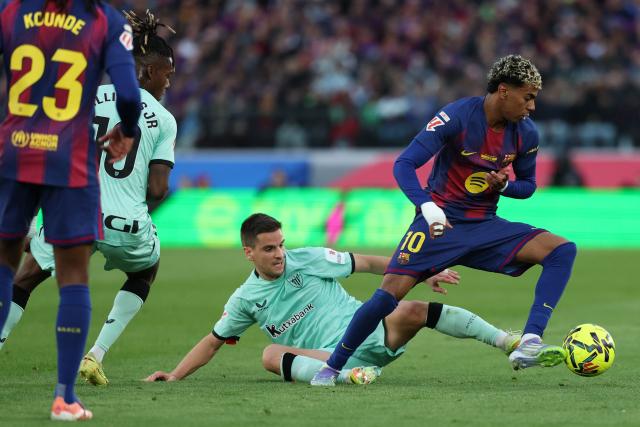 Athletic Bilbao's Spanish midfielder #16 Inigo Ruiz de Galarreta tackles Barcelona's Spanish forward #10 Lamine Yamal during the Spanish league football match between FC Barcelona and Athletic Club Bilbao at Camp Nou Stadium in Barcelona on November 22, 2025. (Photo by Lluis GENE / AFP)