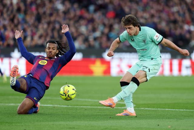 Barcelona's French defender #23 Jules Kounde (L) and Athletic Bilbao's Spanish midfielder #20 Unai Gomez fight for the ball during the Spanish league football match between FC Barcelona and Athletic Club Bilbao at Camp Nou Stadium in Barcelona on November 22, 2025. (Photo by Lluis GENE / AFP)