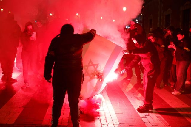 Protestors set an Israel's flag on fire during a rally called by Madrid Anti-Fascist Coordination Committee under the slogan '50 years of Francoist impunity' in Madrid on November 22, 2025. The day before, hundreds of Spanish fascists took part in a demonstration through Madrid, as the country marked the 50th anniversary of divisive right-wing former dictator Francisco Franco's death. Franco's demise on November 20, 1975 ended 36 years of authoritarian right-wing rule that followed a devastating 1936-1939 civil war which brought him to power. (Photo by Pierre-Philippe MARCOU / AFP)